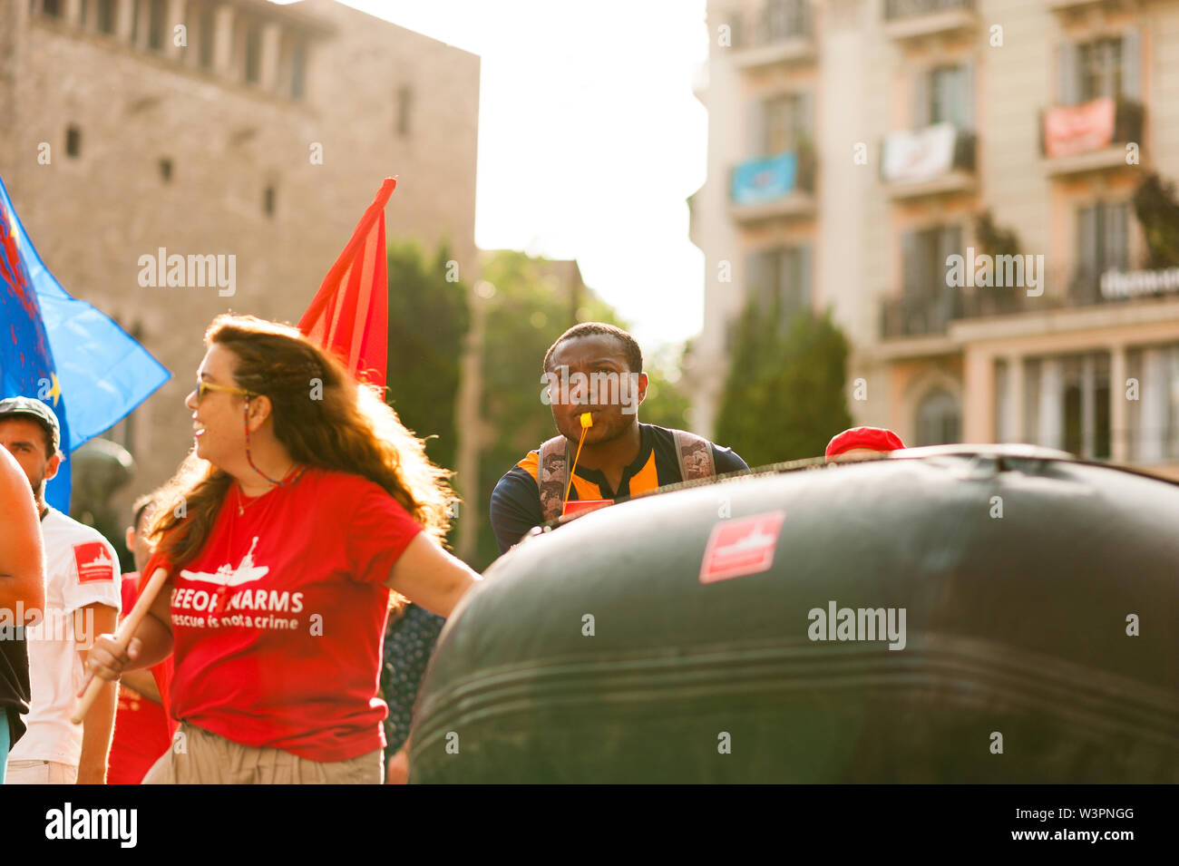 Barcelona, spain- 17 july 2019: young open arms african migrant march holding rubber dinghy and italian minister Salvini mask against immigration poli Stock Photo