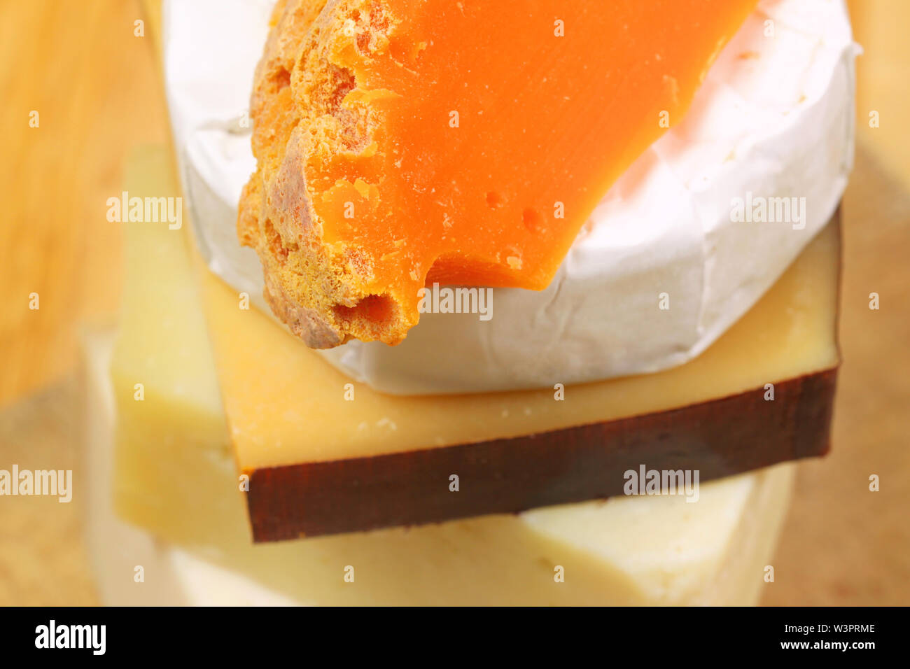 various kinds of cheese stacked. Closeup of mimolette cheese Stock Photo