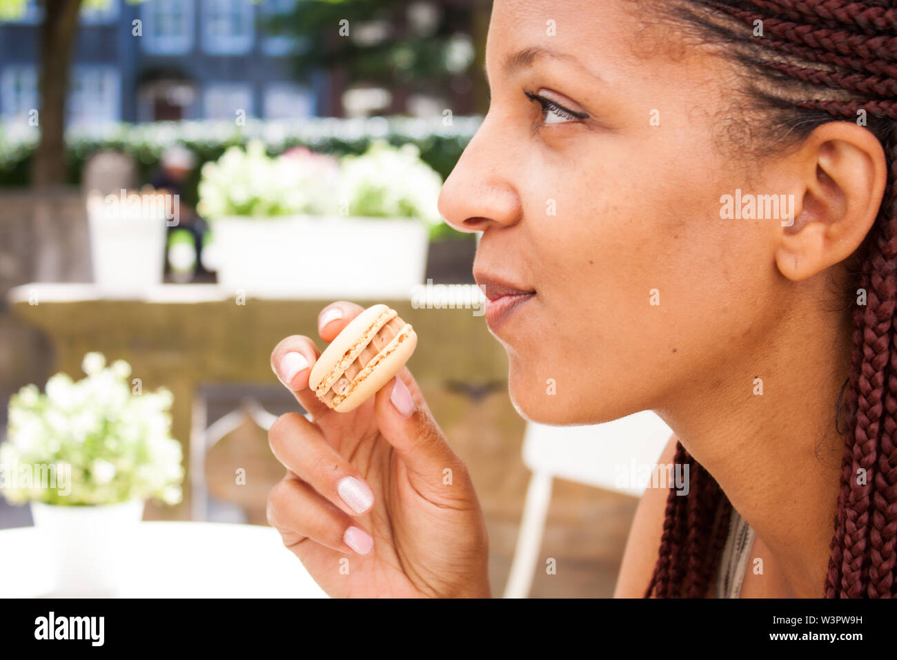 Mixed Race Beautiful Girl Eating Chocolate Macaron In Summer
