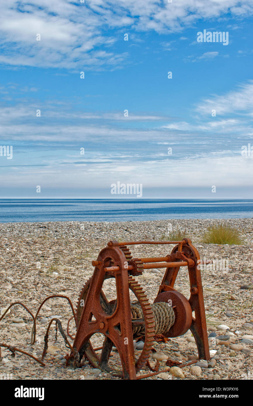 FINDHORN MORAY COAST SCOTLAND IN SUMMER OLD RUSTED CABLE WINCH ON THE BEACH Stock Photo