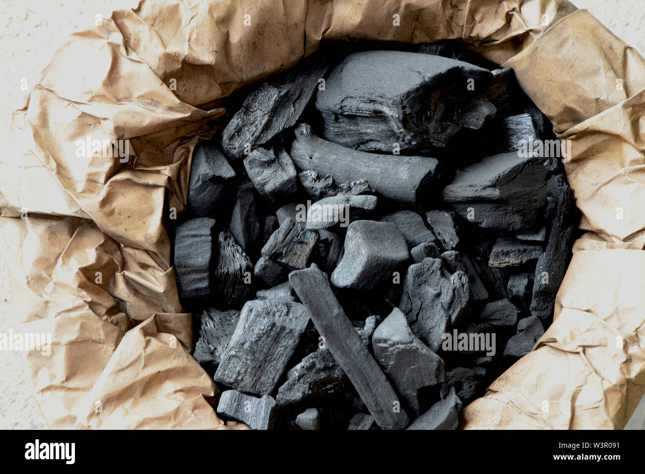 Charcoal for barbecuing in opened paper bag. Germany Stock Photo