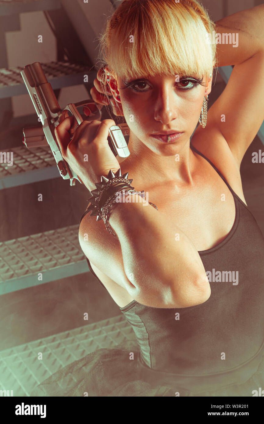 Cyberpunk, Blonde girl with pistols in an abandoned factory. cosplayer, action and dangerous woman Stock Photo