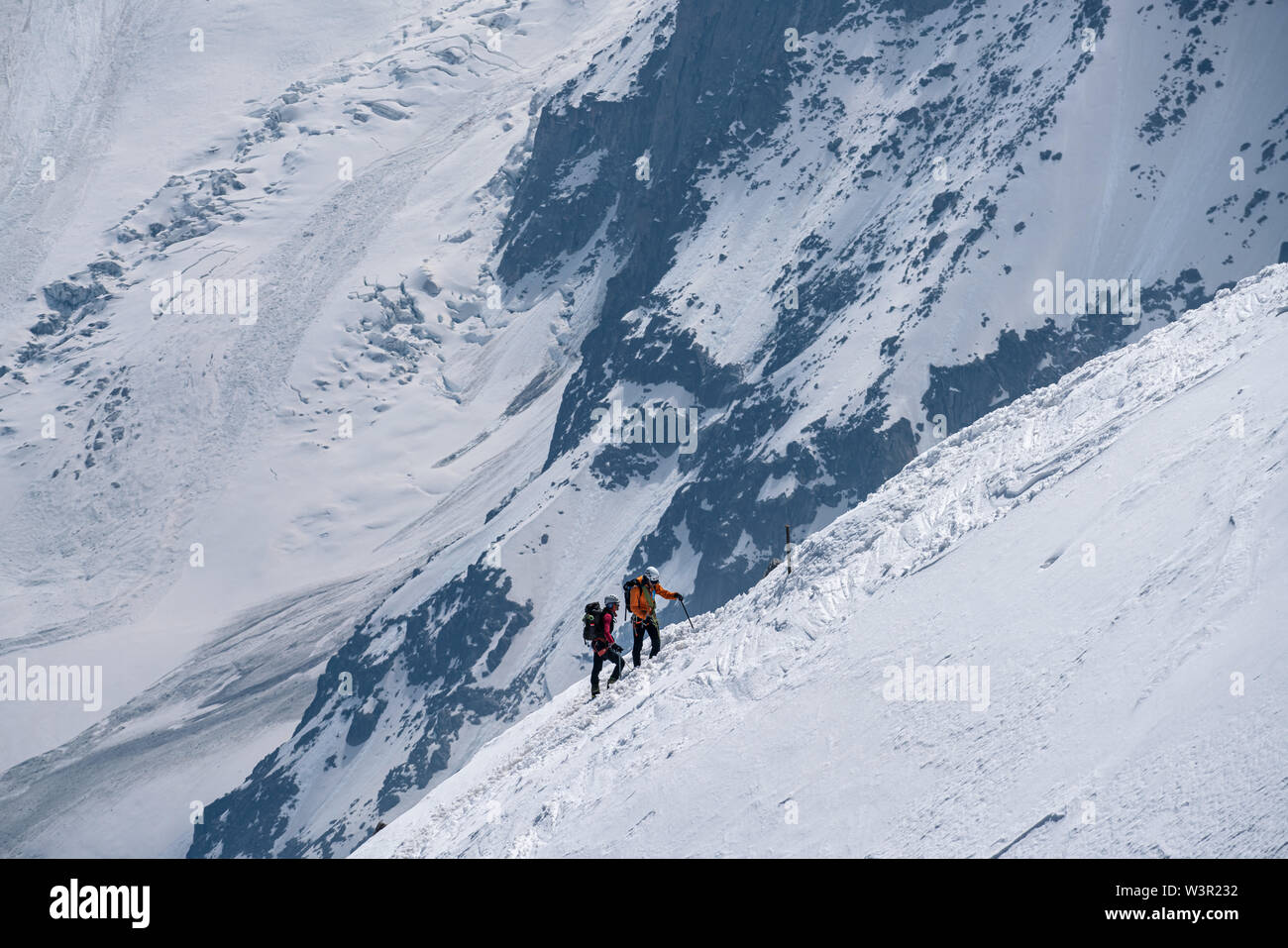 Chamonix, France - 18/06/2019: Mountaineers ascending towards Aiguille du Midi on a snowy ridge. Stock Photo