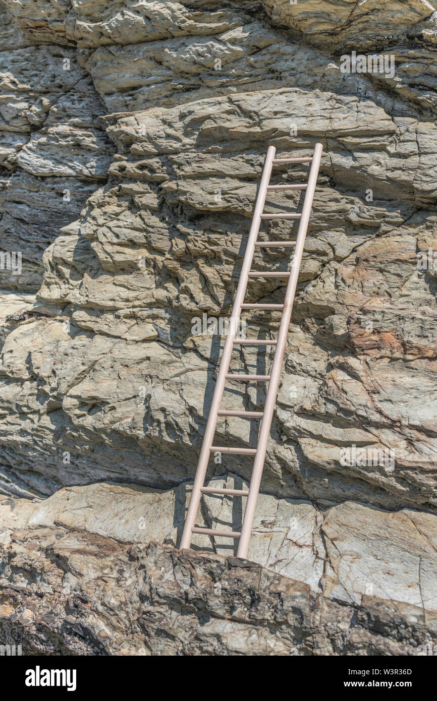Small wood toy ladder propped against cliff face. Metaphor climbing