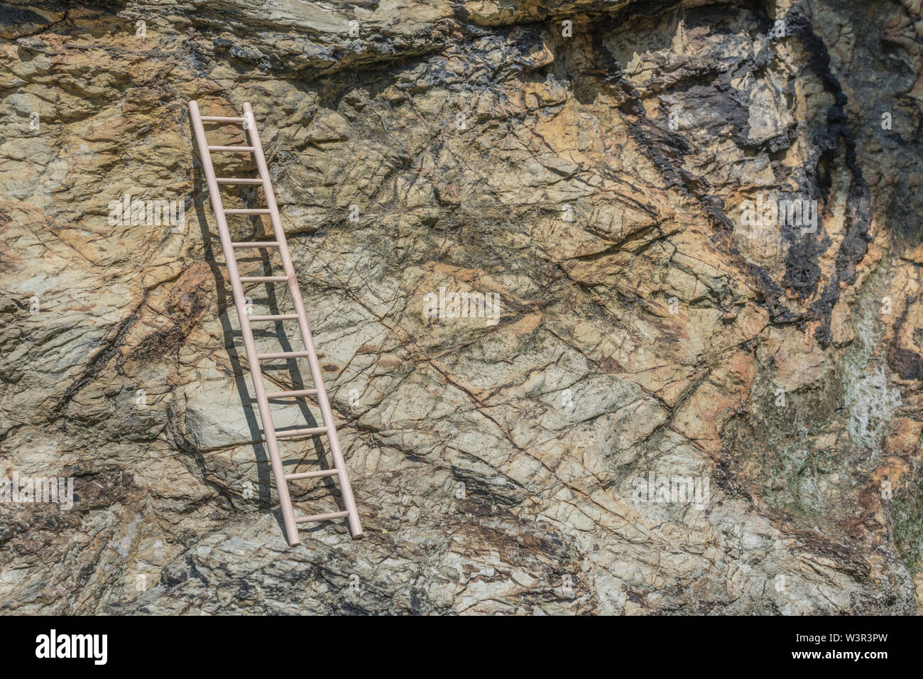 Small wood toy ladder propped against cliff face. Metaphor climbing