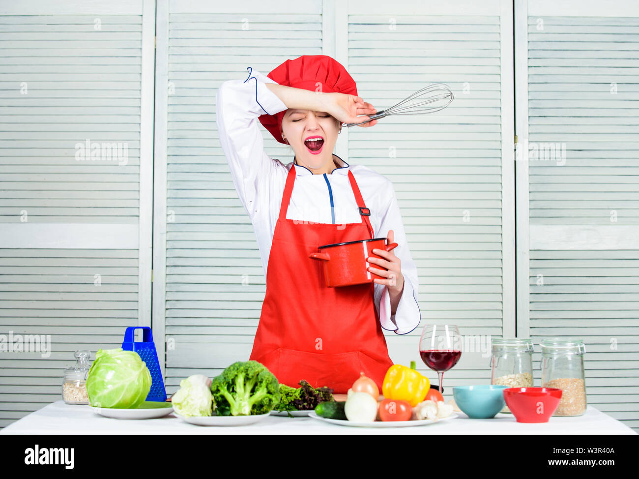 Girl in apron whipping eggs or cream. Start slowly whisking or beating