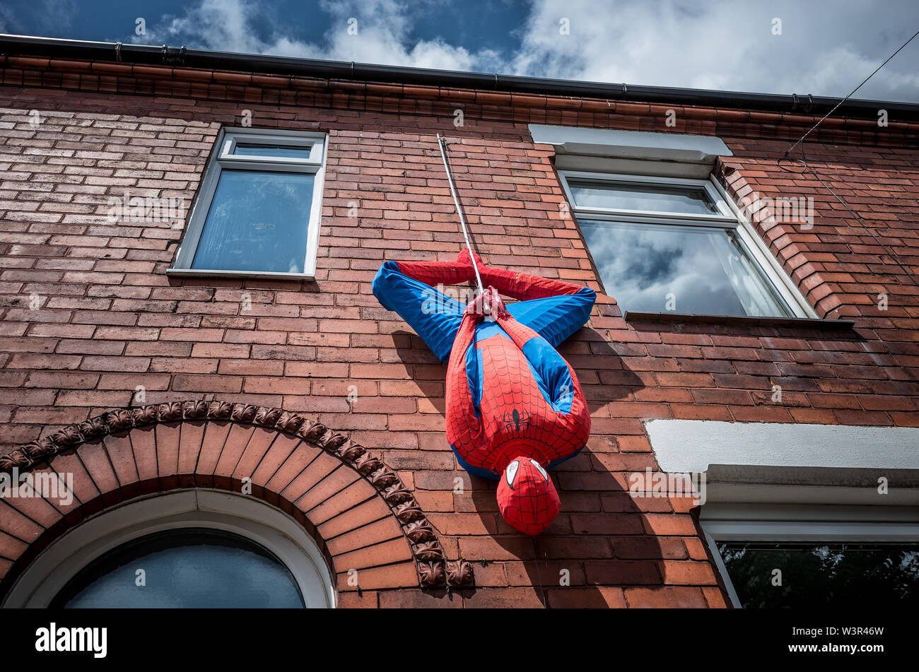 Spiderman scarecrow hanging from a  Victorian terraced house in a village in Cheshire. Stock Photo