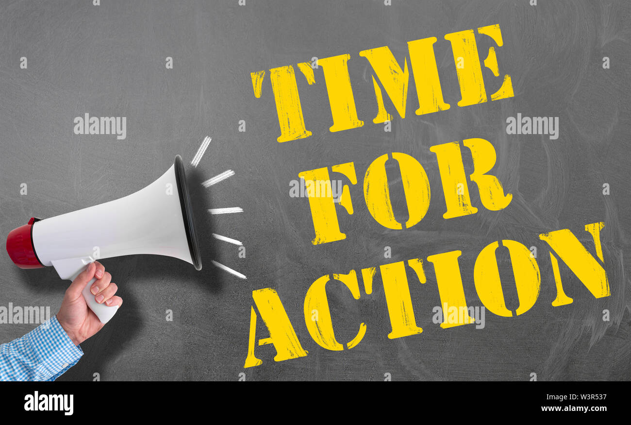 hand holding megaphone or bullhorn against blackboard with text TIME FOR ACTION, no procrastination concept Stock Photo
