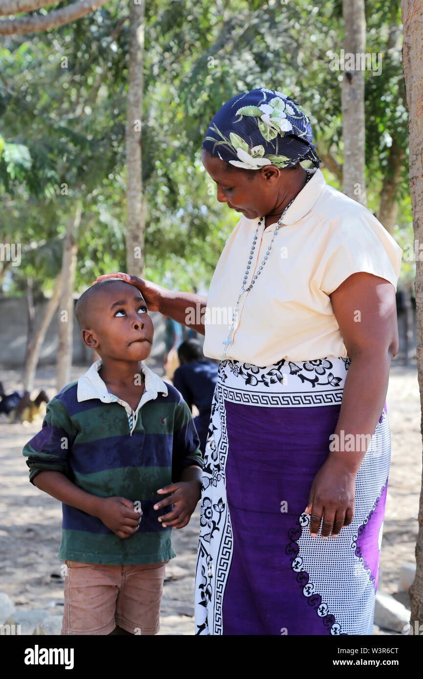 catholic catechist comfort a sad boy of Epiphany Pre- and Primary School in Bagamoyo, Tanzania, Africa Stock Photo