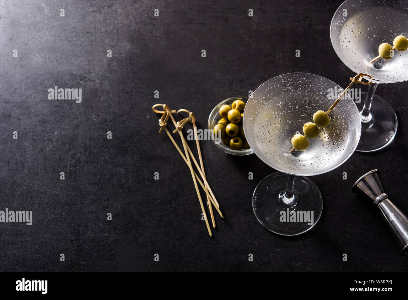 Classic Dry Martini with olives on black background.Copyspace Stock