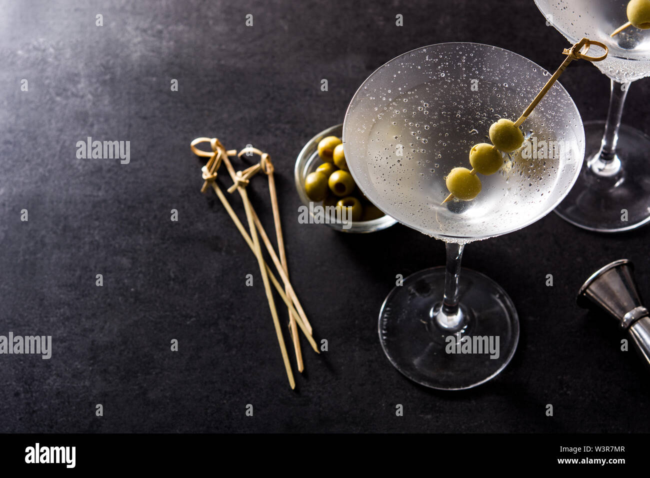 Classic Dry Martini with olives on black background.Copyspace Stock