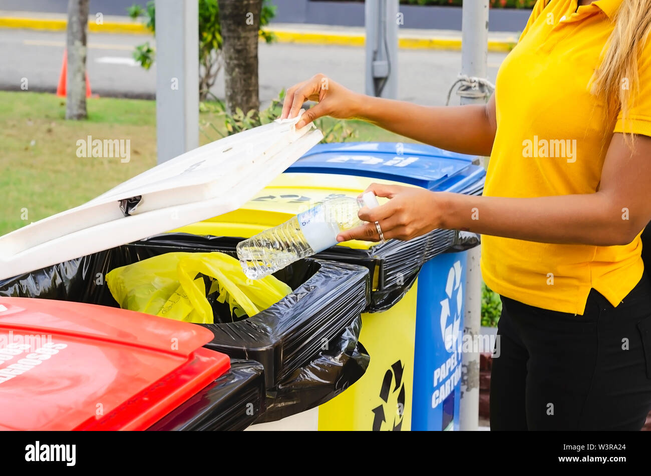 recycling of plastic bottles, girl of 20 to 25 years placing plastic bottle in deposits for processing Stock Photo