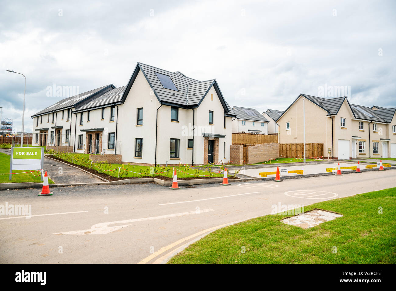 Newly built energy efficient houses with solar panels on the roof for sale in a housing development in Scotland on acloudy spring day Stock Photo