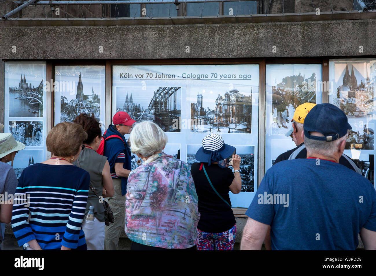 people look at 70 year old photos of destroyed Cologne, which are exhibited near the cathedral, Cologne, Germany  Menschen schauen 70 Jahre alte Fotos Stock Photo