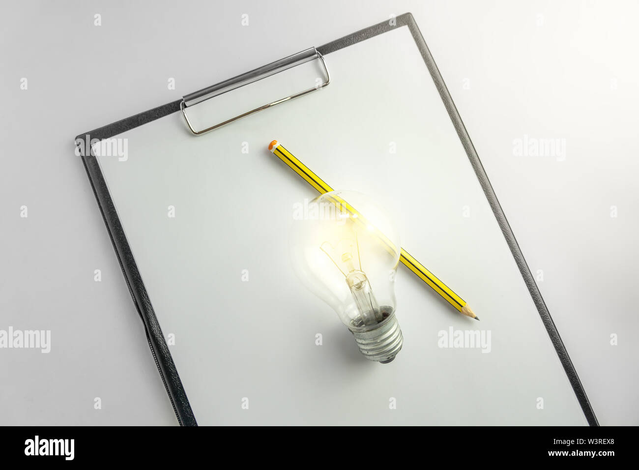 Blank paper with an light bulb and pencil waiting for idea concept with light Stock Photo