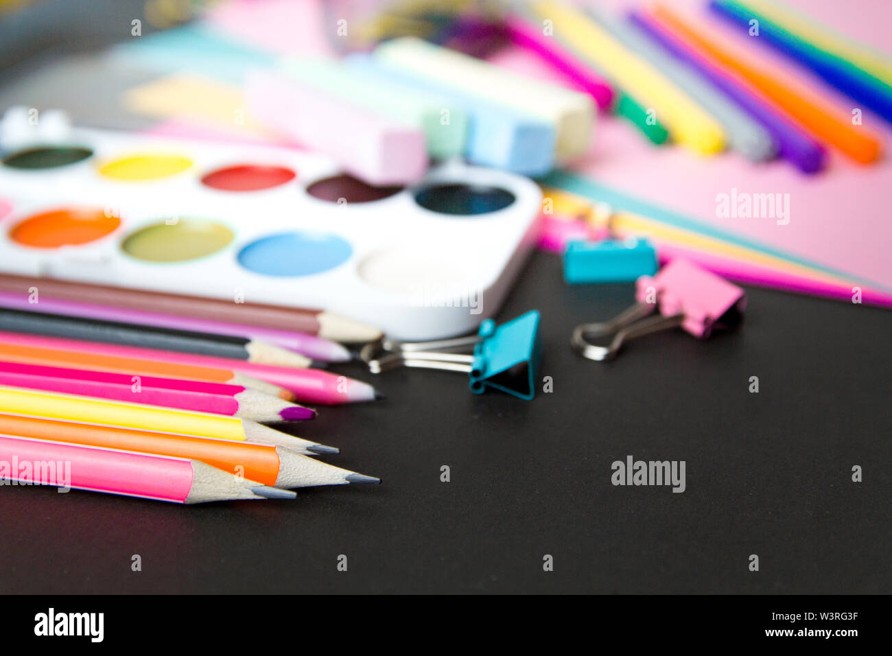 School and office supplies on a blackboard.Colored paper, pencil, paint ...