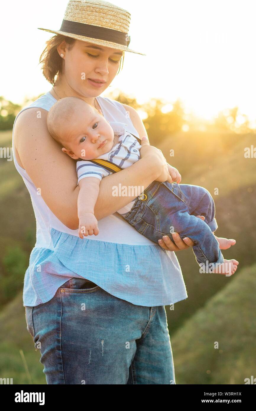 Mom with baby spending time together at sunset, on summer  Stock Photo