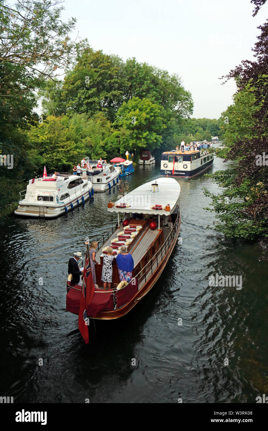 Hurley, Berkshire, UK. 17th July, 2019. Pleasure boast Alaska the Waterman following the swan uppers as they leave Hurley Lock on day three of Swan Upping 2019. A week long survey of the the swans on the River Thames, from Sunbury in Surrey to Abingdon in Oxfordshire. The Royal Swan Uppers, who wear the scarlet uniform of Her Majesty The Queen, travel in traditional rowing skiffs together with Swan Uppers from the Vintners' and Dyers' livery companies. Credit: Julia Gavin/Alamy Live News Stock Photo