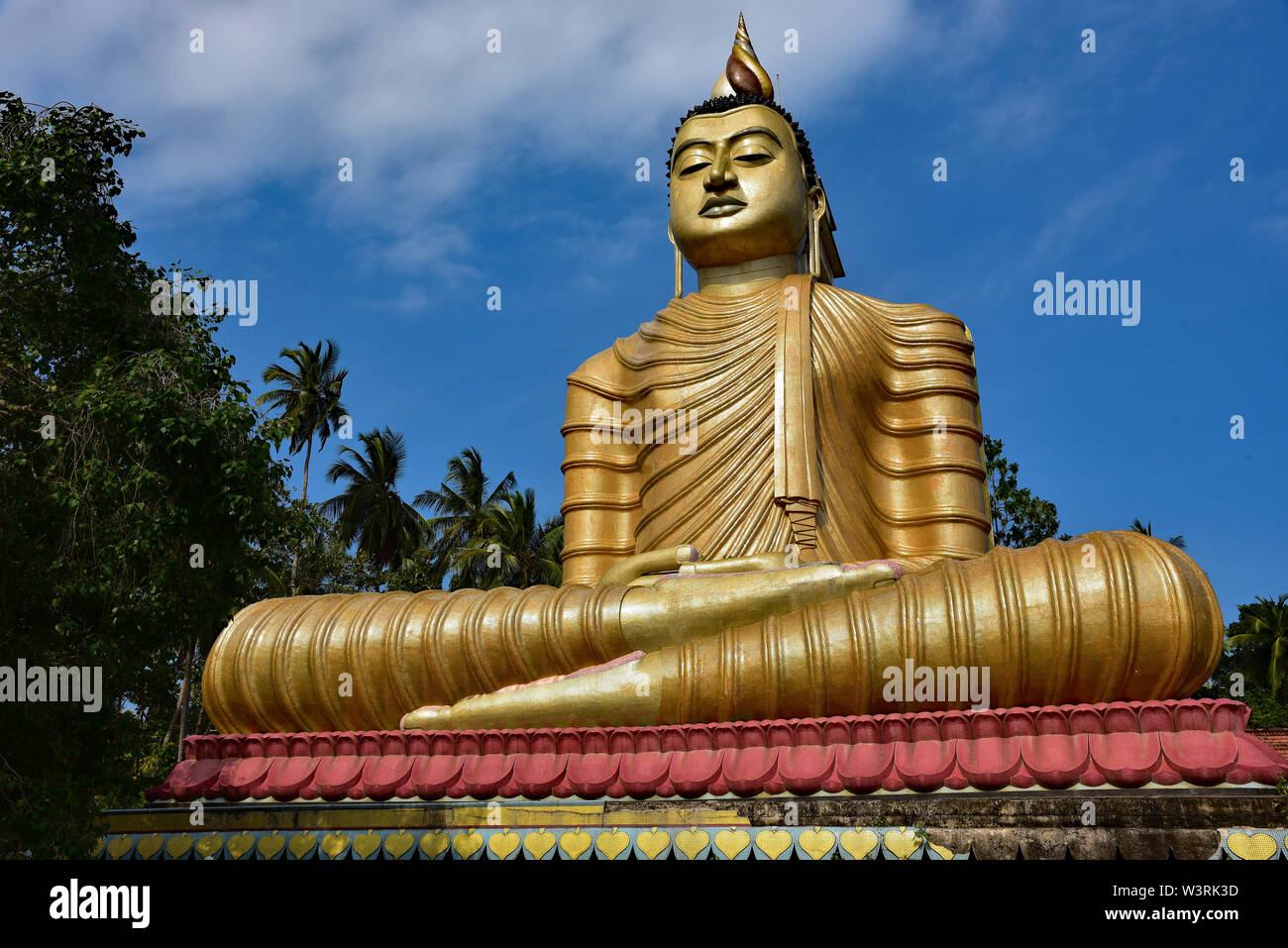 The colourful temple of Wewurukannala Vihara, 2 miles north of Dikwella, home to the largest seated golden Buddha in Sri Lanka, Asia. Stock Photo
