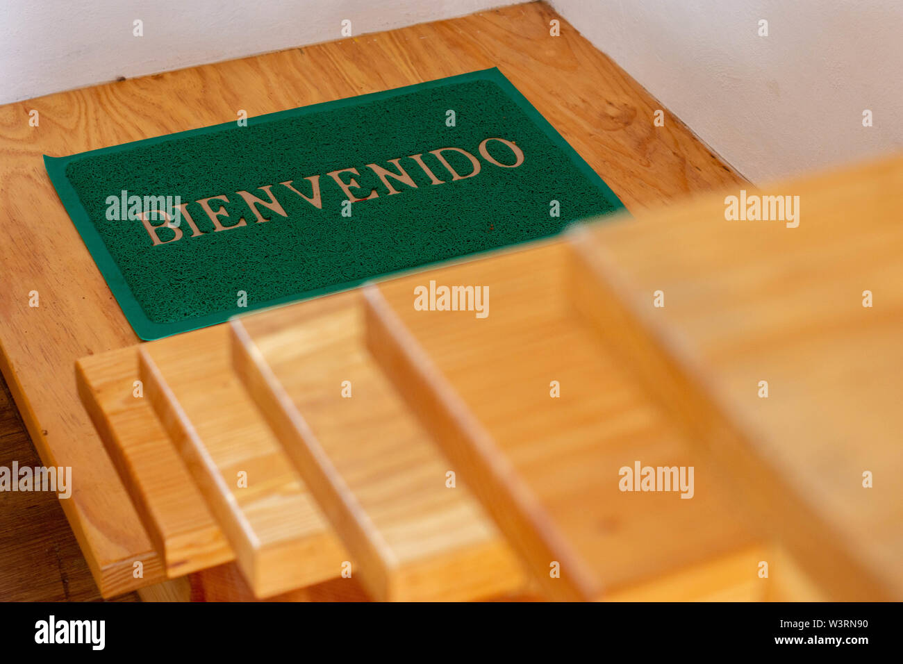 Welcome mat on wood stairs in spanish Stock Photo