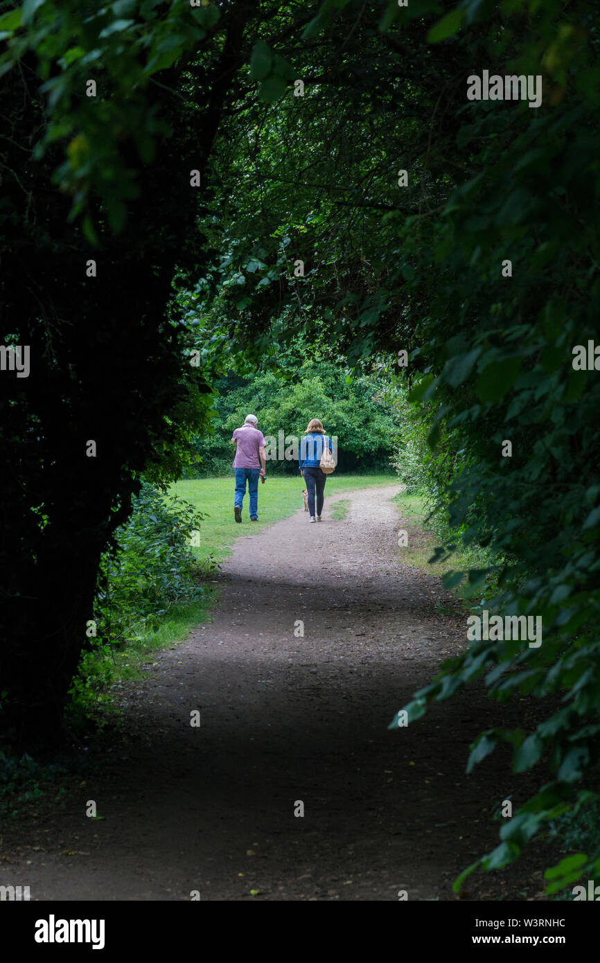 Couple walking in park dog hi-res stock photography and images - Alamy