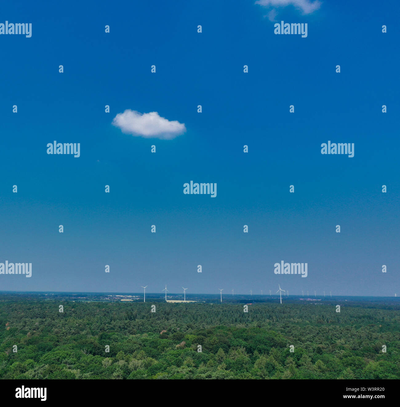 Horizontal aerial view to the horizon with blue sky, much copy space, a small cloud and windmills Stock Photo