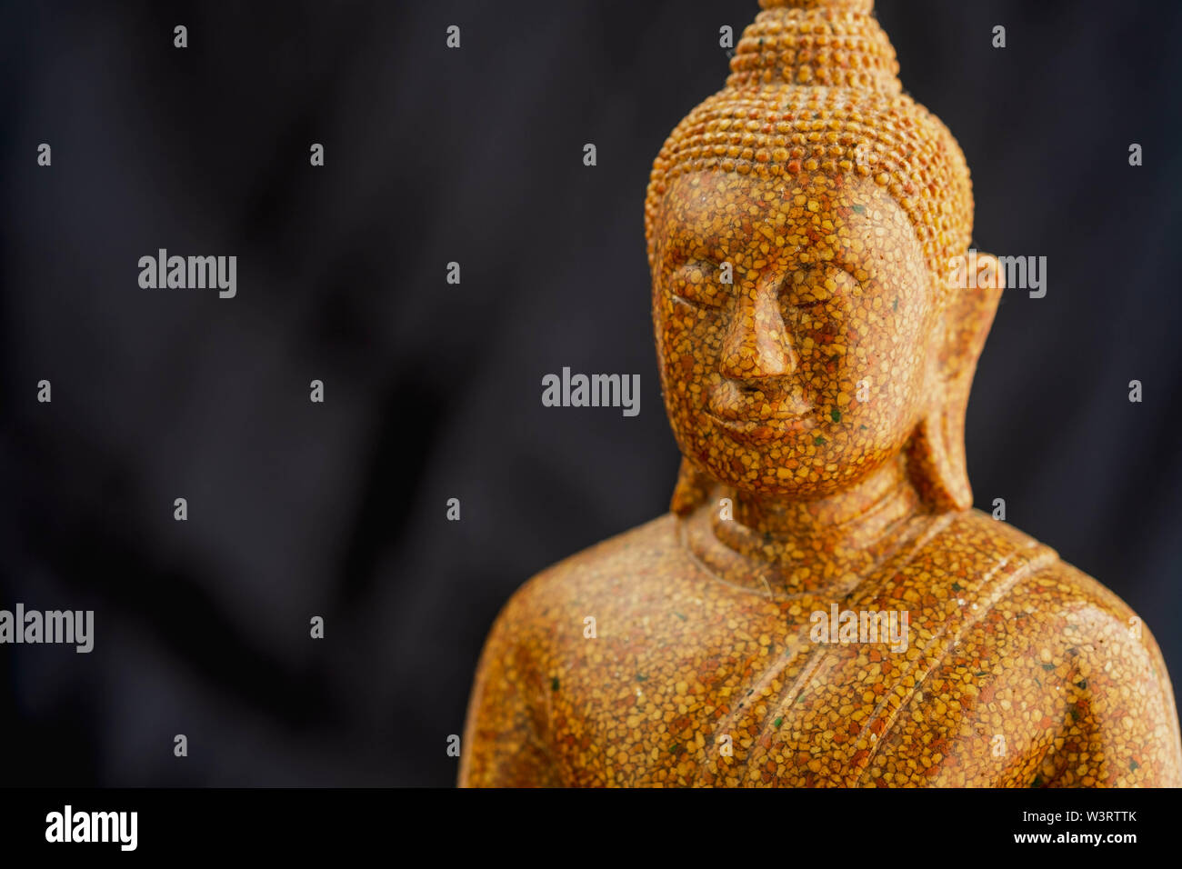 Buddha stone sculpture close-up black background macro Stock Photo