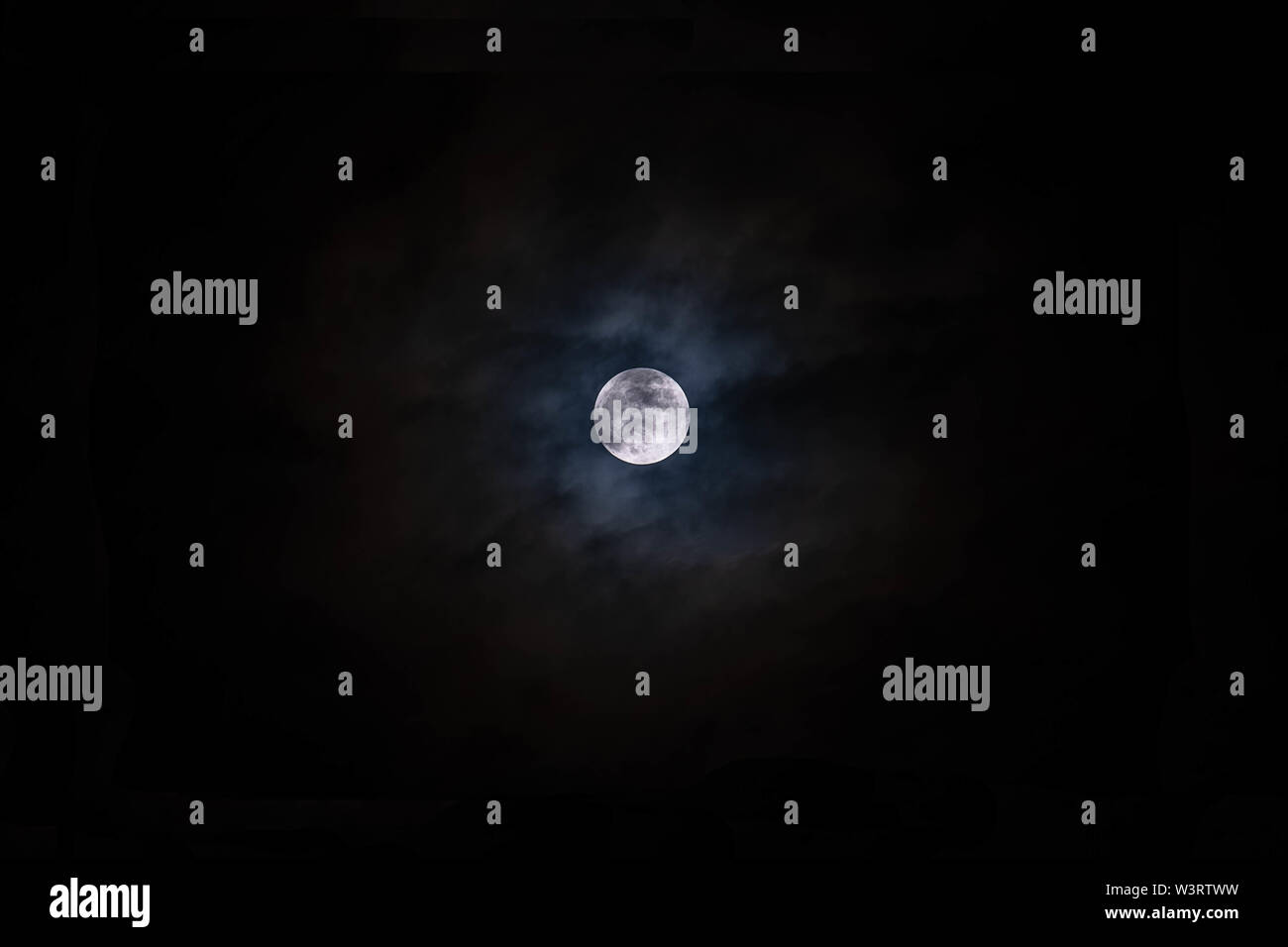 Full moon with clouds black background backdrop detail surface Stock Photo
