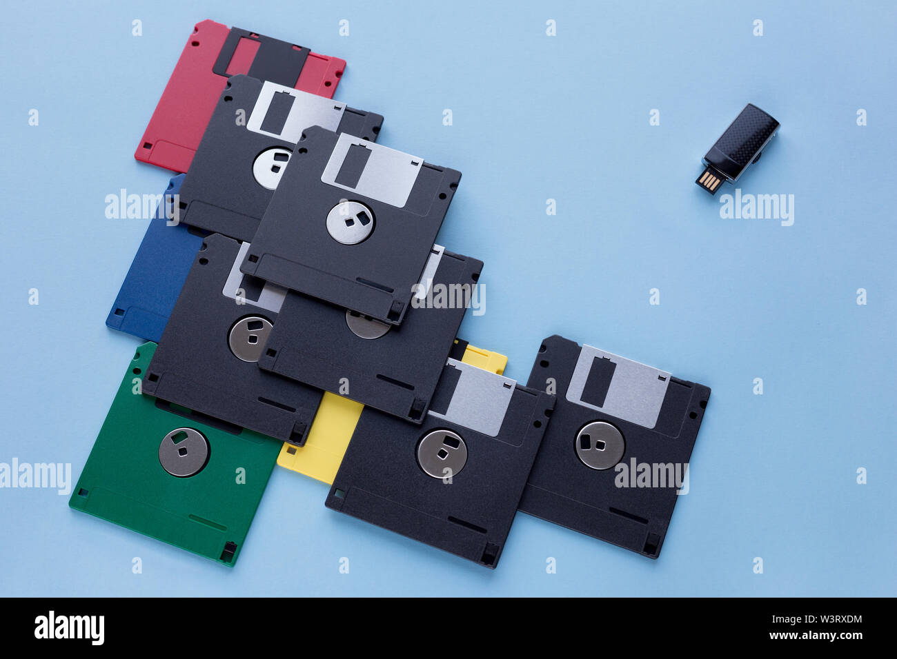 The evolution of digital data storage device. Floppy disks vs small flash drive. Isolated on a