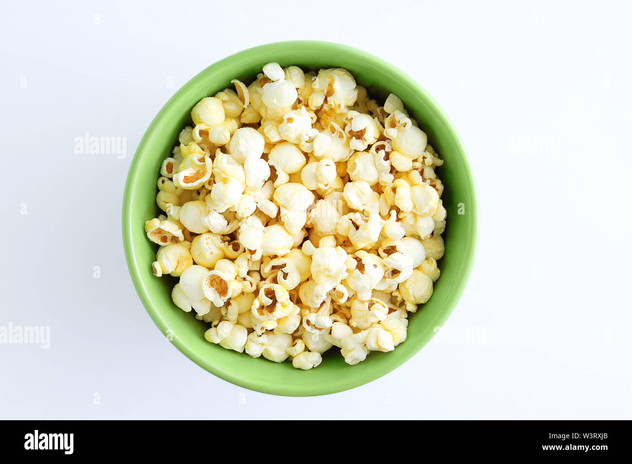 Fried popcorn in a green bowl. White background. Stock Photo