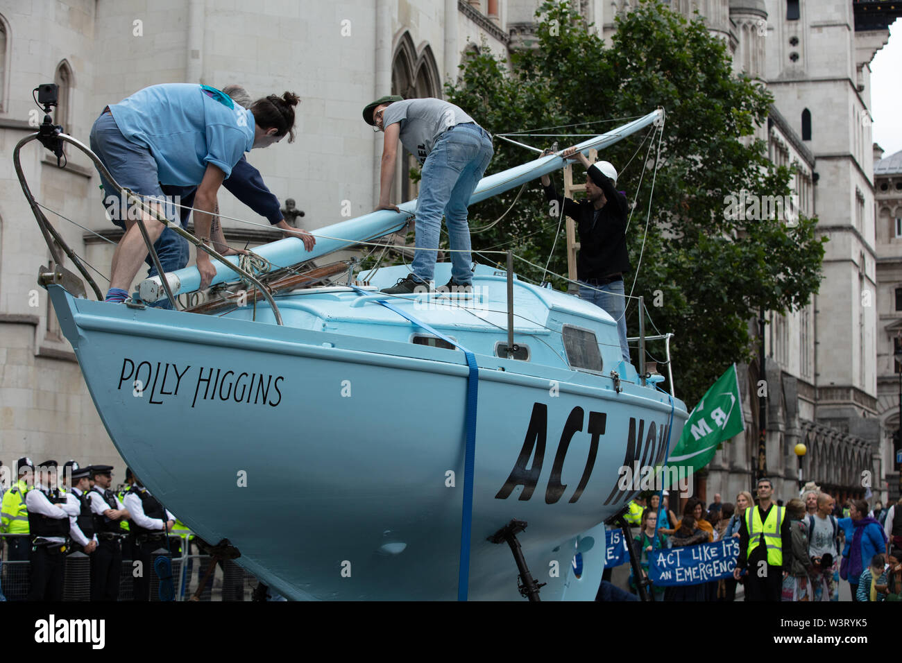 London, UK. 15th July 2019. The climate action group Extinction Rebellion raise a mast on the boat Polly Higgins outside the Royal Courts of Justice, London, whilst holding protests on several places in the UK such as here on the Strand, London, closing part of the street, demanding a law on Ecocide. Credit: Joe Kuis / Alamy News Stock Photo