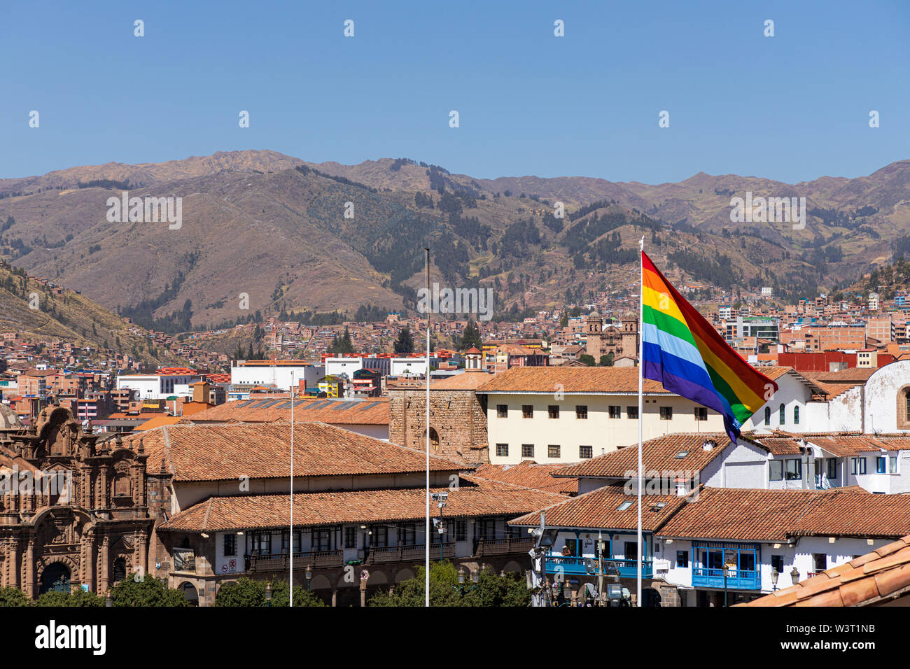 Cusco flag flying over the rooftops in the Plaza de Armas, Cusco, Peru, South America Stock Photo
