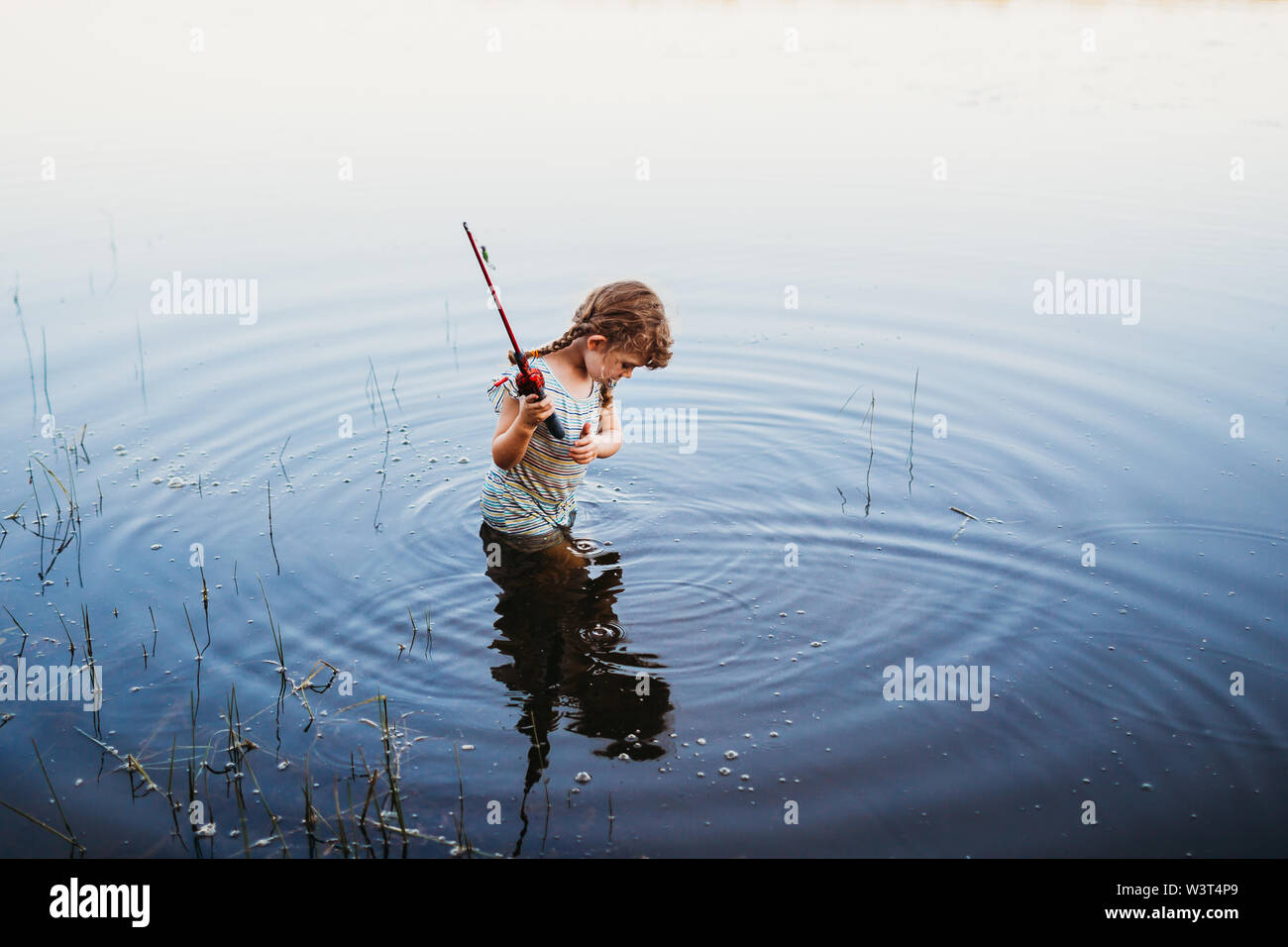 Young girl standing holding fish hi-res stock photography and