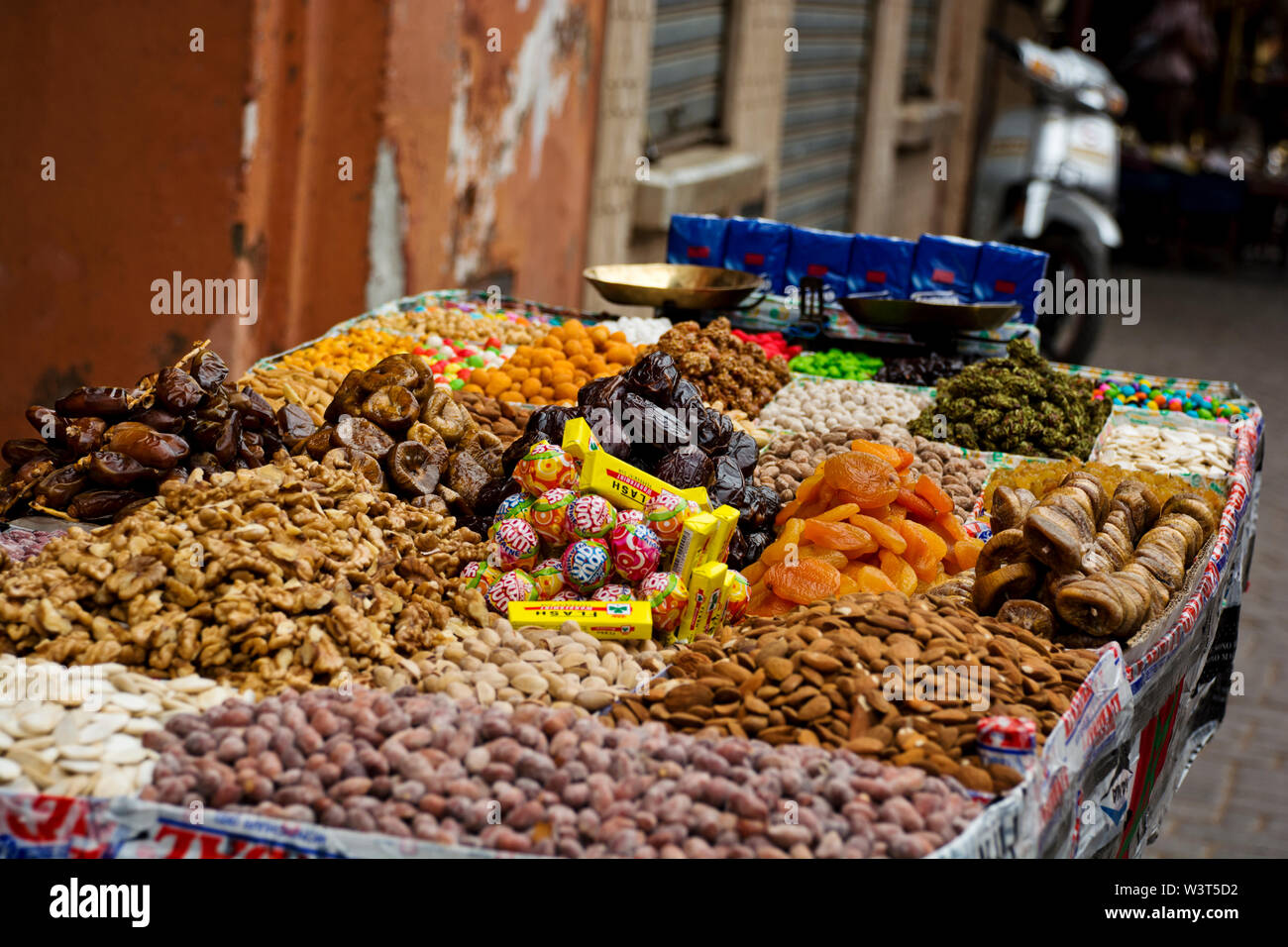 Local Moroccan stalls selling nuts, sweet goods in the streets, alleyways of Marrakech going about daily arabic life in the cultural Medina Stock Photo