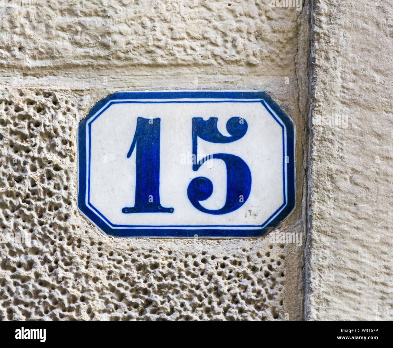 house number fifteen ( 15 ) on a roughcast wall Stock Photo
