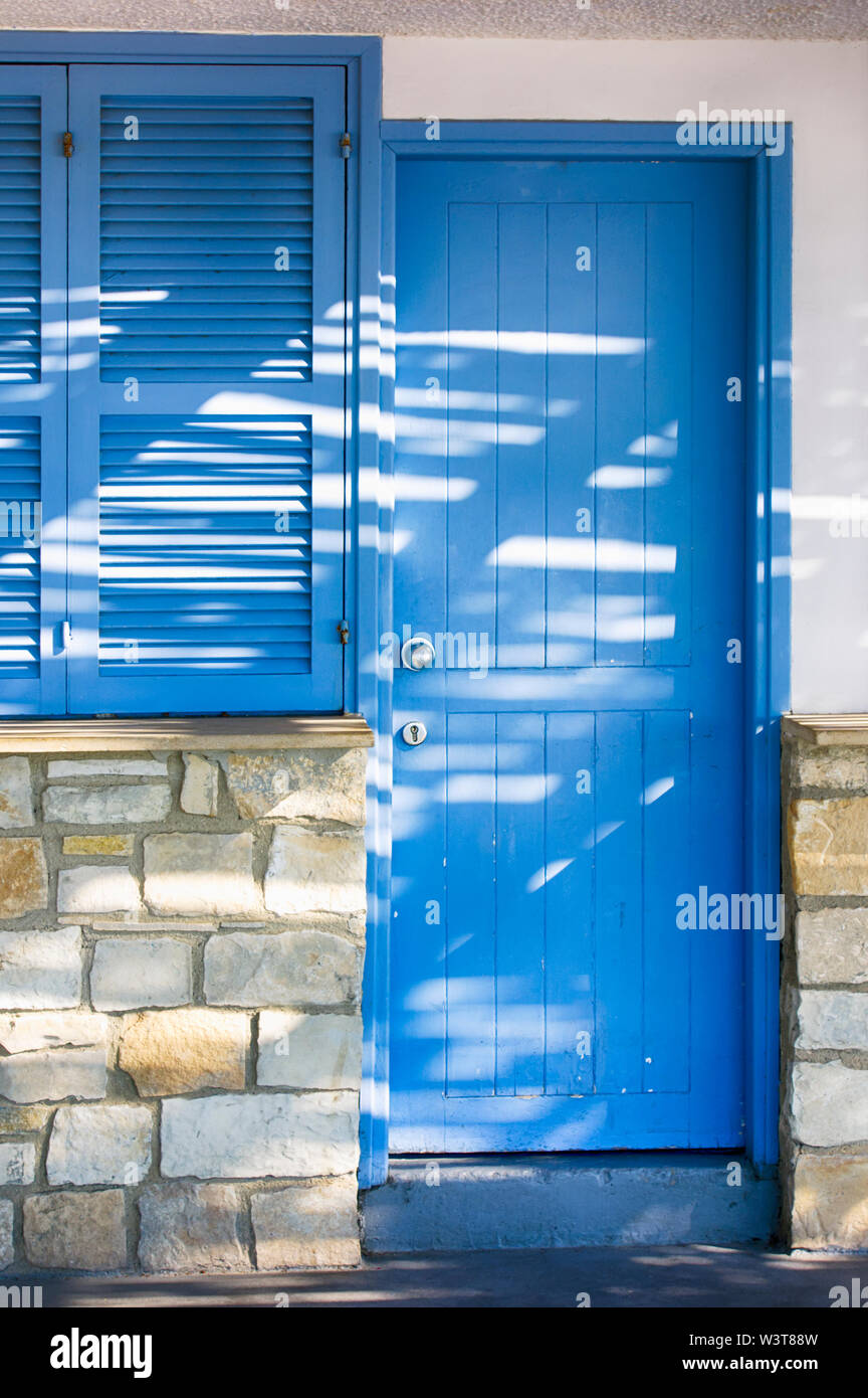 Closed blue door of mediterranean house and closed window. Close-up. Stock Photo