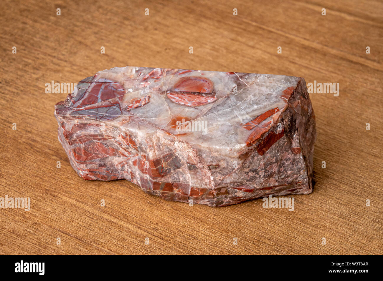 Red gemstone with colorful structure in many tones formed under high pressure Stock Photo