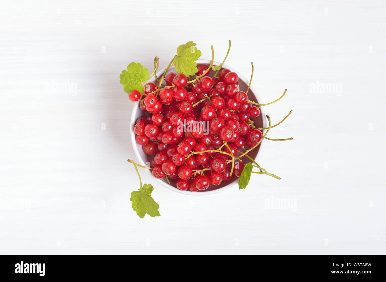 Red currants in white bowl on table, top view Stock Photo