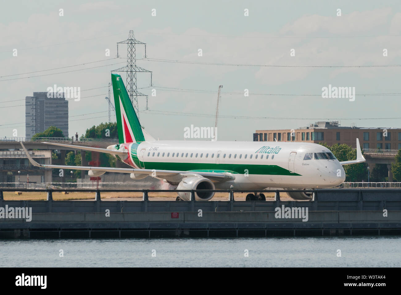 London, Uk - August 2, 2013 - Alitalia regional airplane taxiing at London City Airport after landing Stock Photo