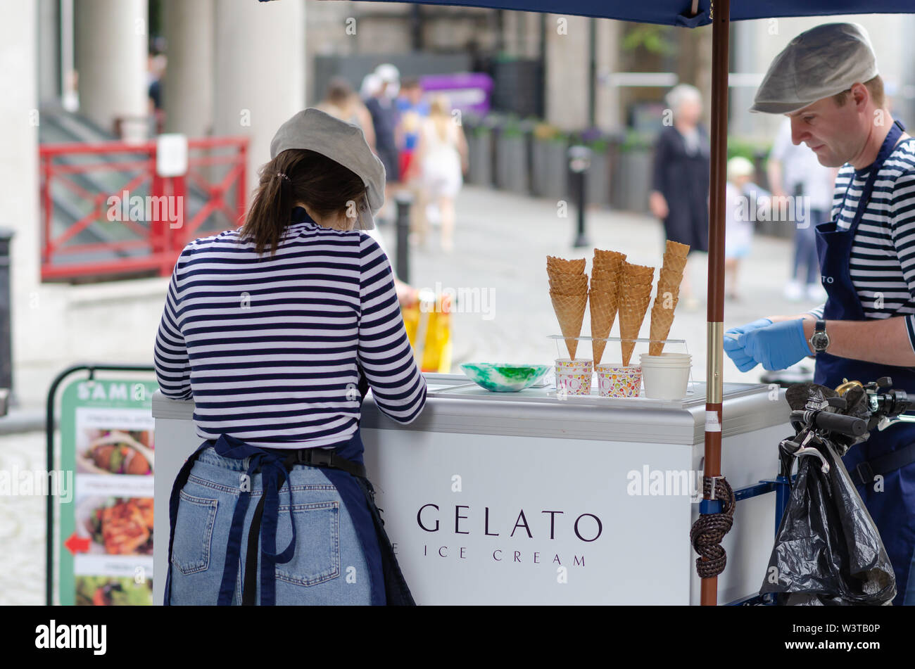 Young girl and a man are selling Gelato ice cream in the London street, near to the Tower Bridge. Stock Photo