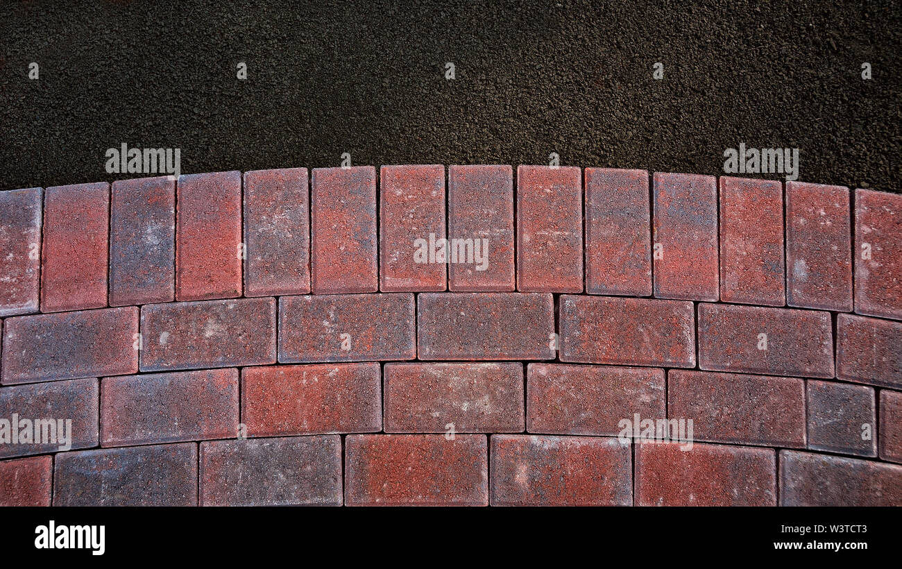Curved brick walkway under construction with paving bricks (Pavers) on aggregate base Stock Photo