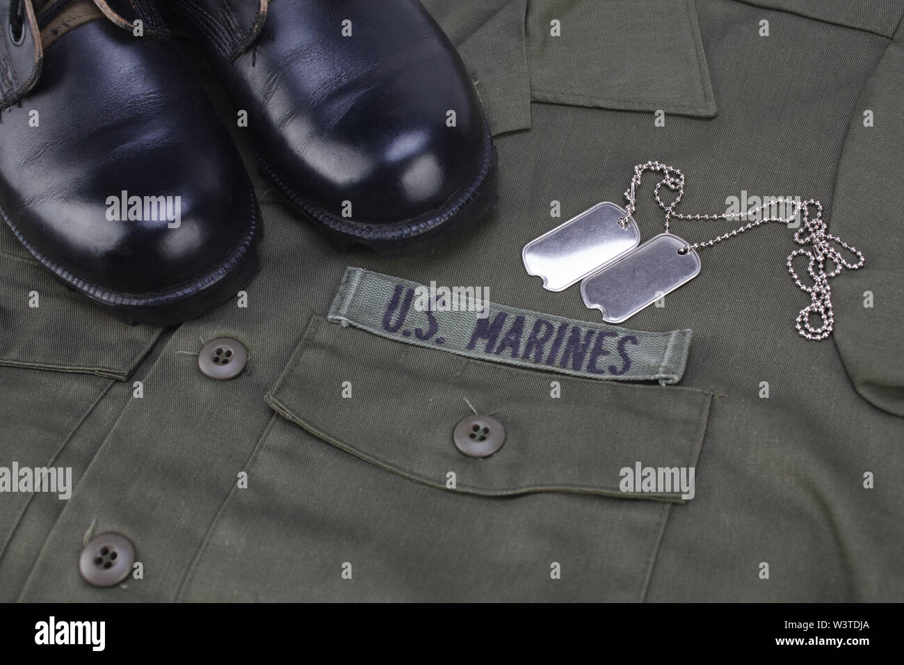 U.S. MARINES Tape with dog tags and boots on olive green uniform