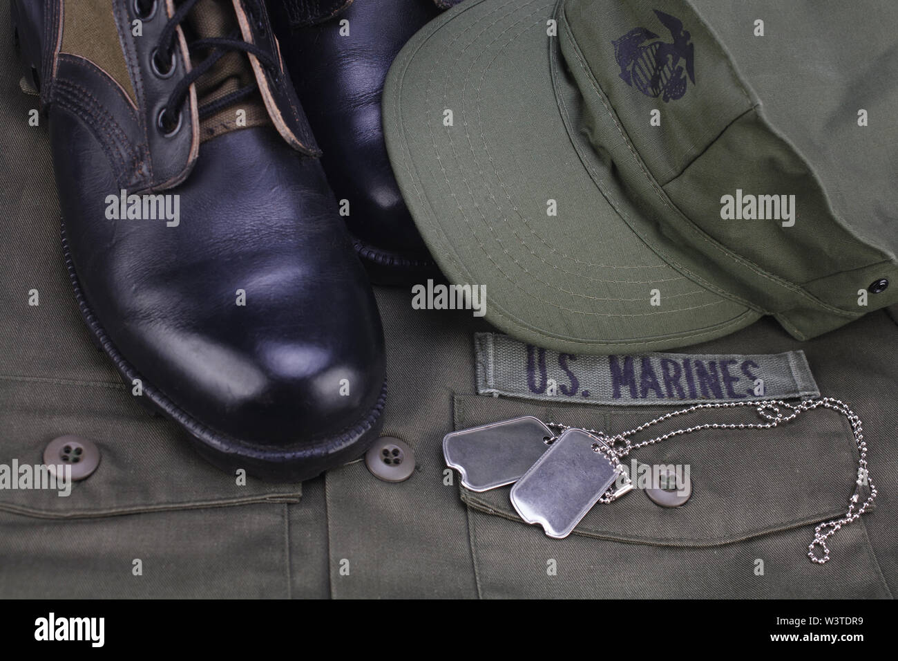 U.S. MARINES Tape with dog tags and boots on olive green uniform