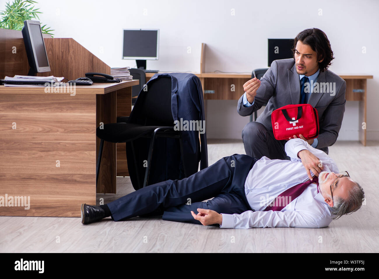 The male employee suffering from heart attack in the office Stock Photo
