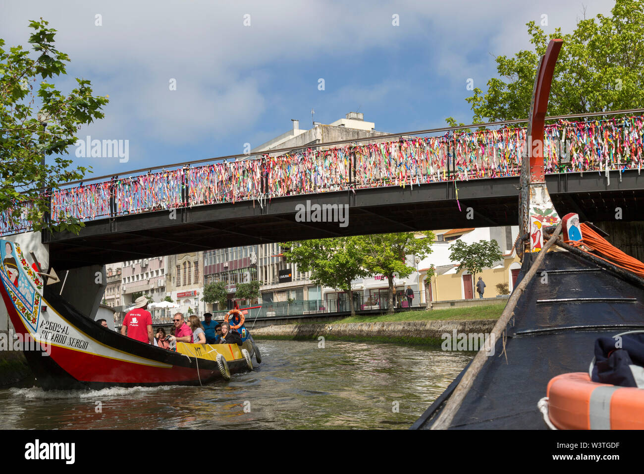 Tourists enjoying a ride on the Cojo canal, in moliceiro boats in The. Portuguese city of Aveiro. Stock Photo