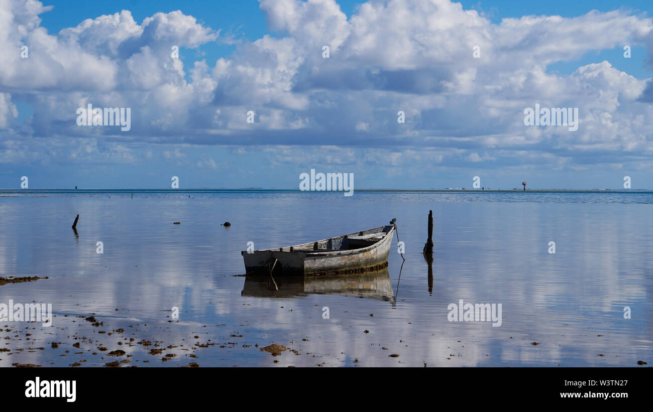 An old dinghy sits on the still waters of Kaneohe Bay, Oahu, Hawaii Stock Photo