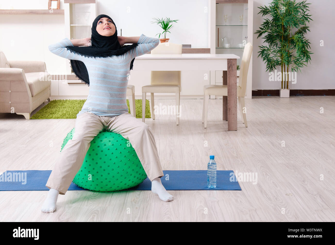 The young woman in hijab doing exercises at home Stock Photo - Alamy