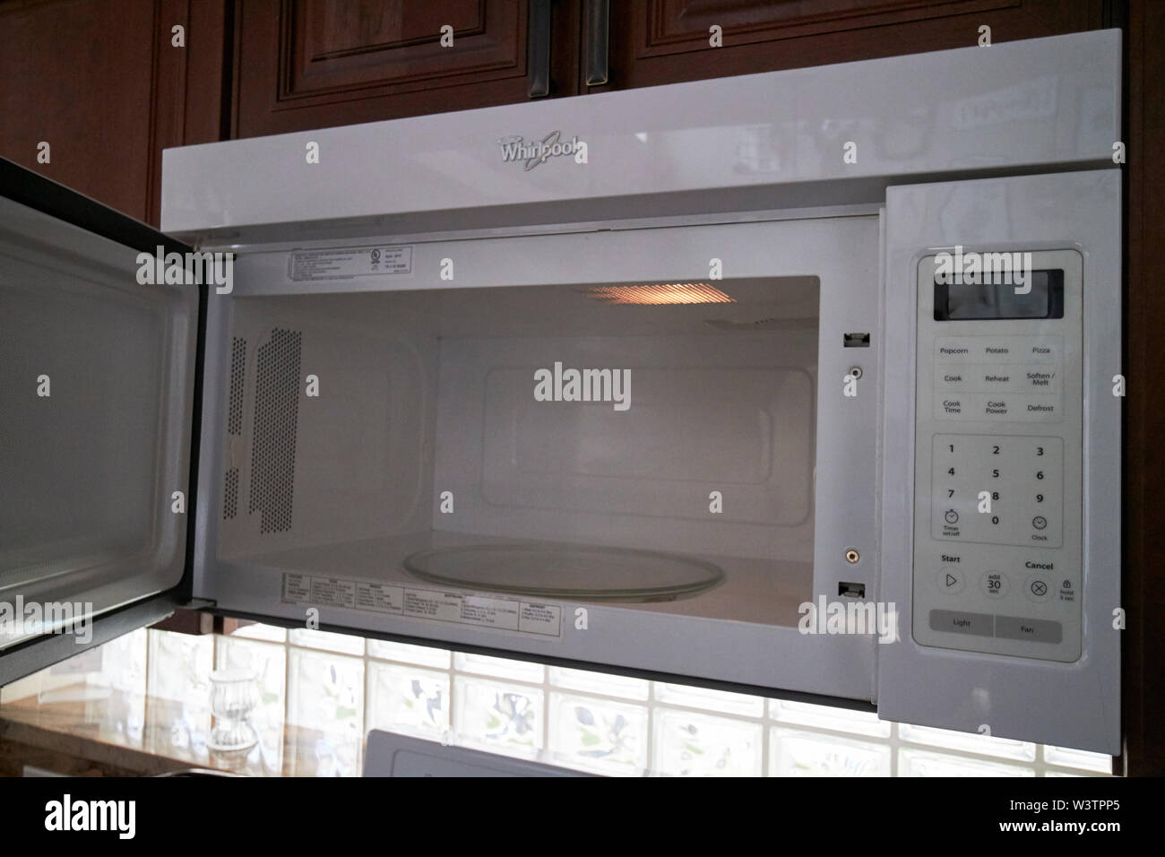 open door of a whirlpool microwave oven in a kitchen in the USA United States of America Stock Photo