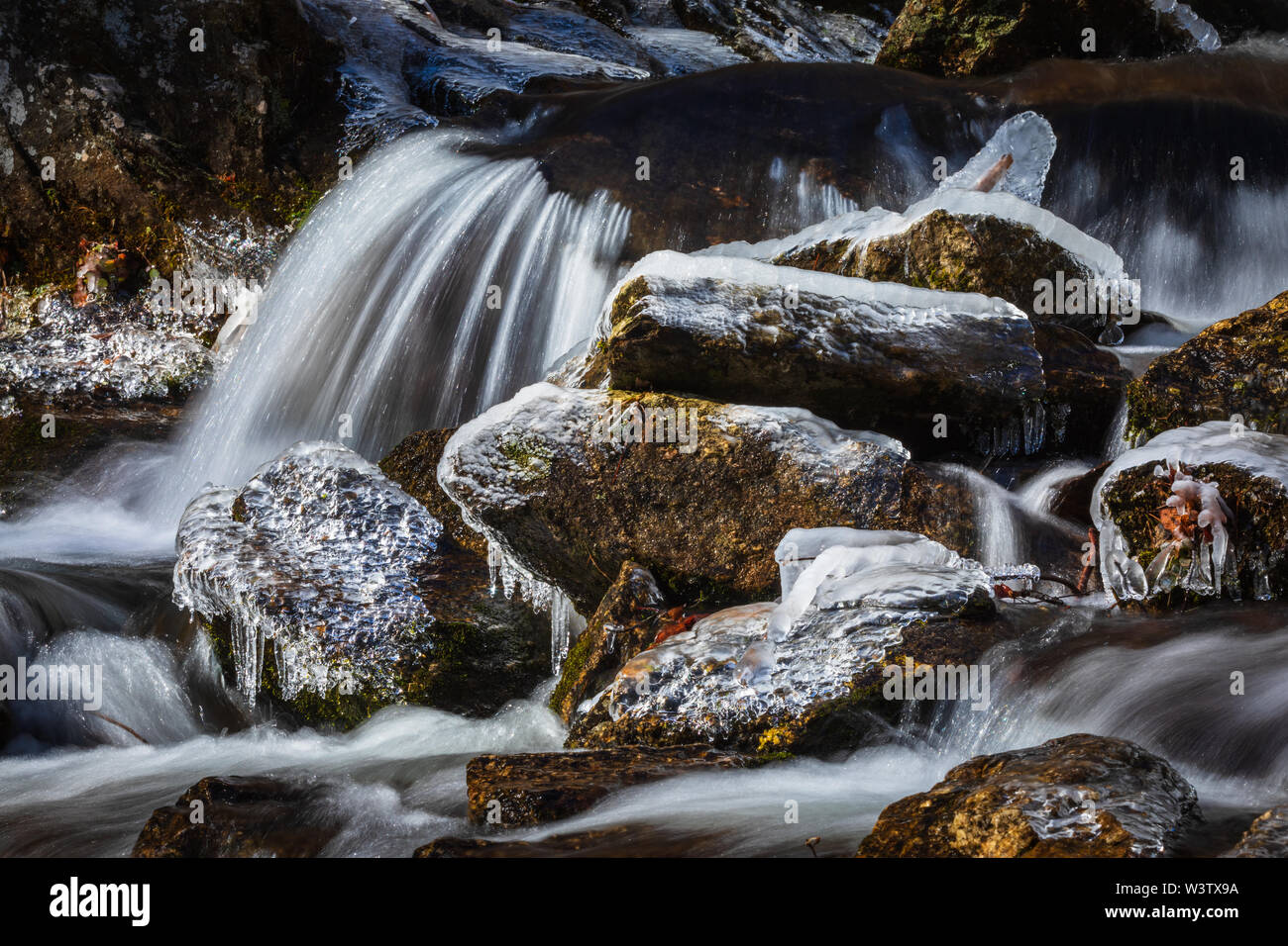 Close up view of an icy Tom's Creek below the falls near Marion, North Carolina, USA. The 60-foot falls are located on Tom's Creek, near Marion, NC. T Stock Photo