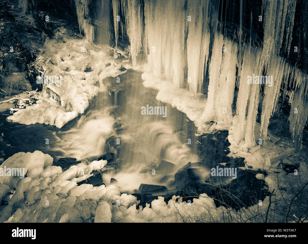 Duotone of a part frozen Grassy Creek Falls, near Little Switzerland, North Carolina, USA. Stock Photo